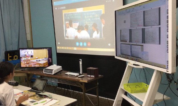 画像：4年生：受信側】RICOH UCSで、児童の様子を撮影し、B小学校へ配信。Web会議システムで、B小学校の先生をスクリーンに投影。