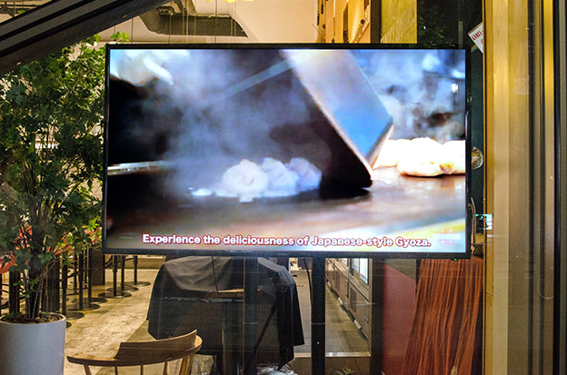 画像：巨大な鉄板で餃子を焼き上げるオープンキッチンなど、店内の様子を動画で紹介。