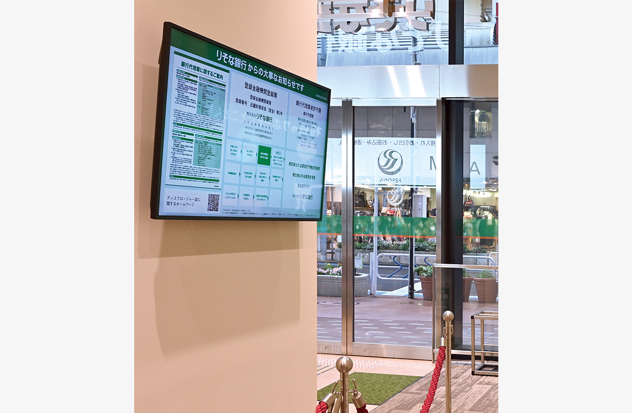 ATMコーナーの背面 法令で掲示が義務付けられている各種情報をデジタルサイネージに集約。