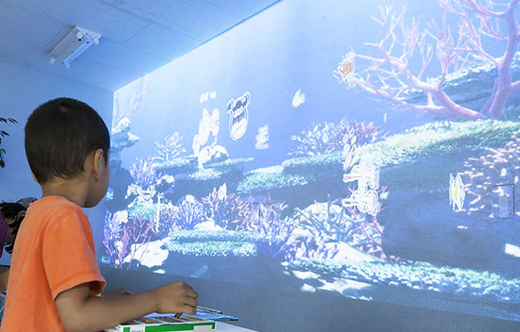 子どもとプロジェクターで映し出されたアートアクアリウムの画像