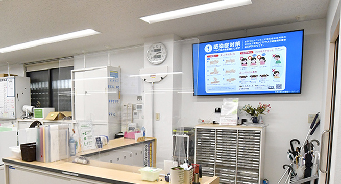 職員室の壁面に設置された感染症対策を促すデジタルサイネージ