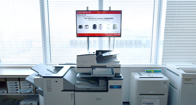 コピー機の上に設置されたデジタルサイネージ例