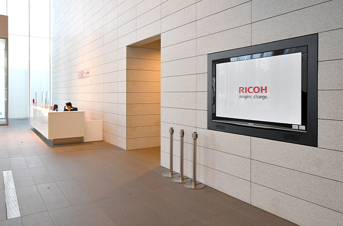 オフィスの受付の壁に設置されているデジタルサイネージ