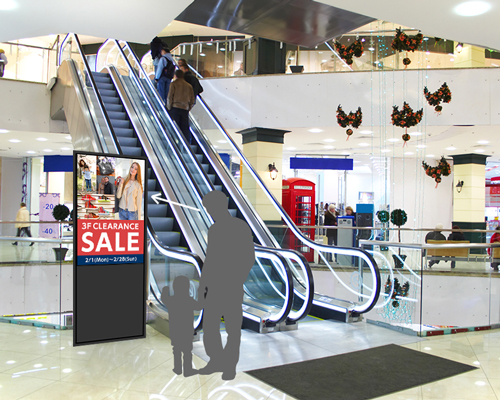 商業施設のエスカレーター前に設置されたデジタルサイネージ