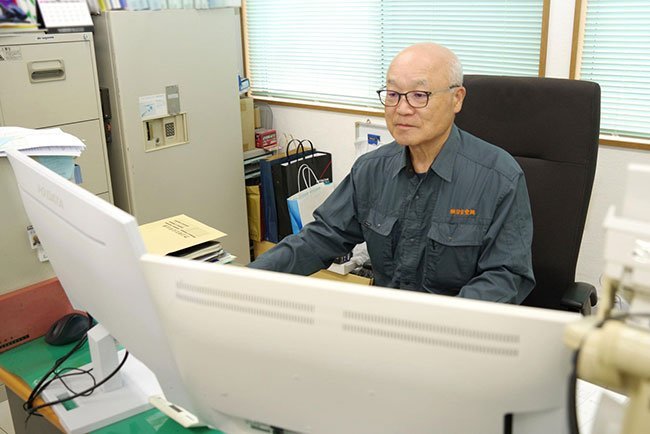 デスクでパソコンを使った作業をする日吉空調の寺内社長