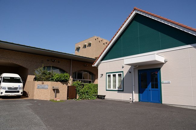 左はデイサービス棟。右の建物つむぎハウスには、フードバンクや地域包括支援センター、高齢者リハビリ室、カフェが入っている