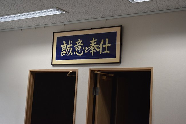 本社1階の事務所に掲げられた社是「誠意と奉仕」。地域医療を支え続ける栗原レントゲンの礎となっている