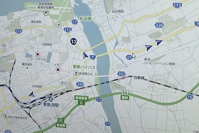 新潟市内で稼働中の車両の位置情報が青い矢印で示されている