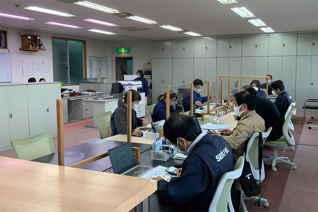 パソコンや複合機を使って仕事をしているオフィス