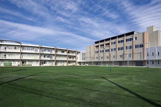 人工芝のグラウンドを備えた学舎