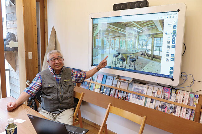 電子黒板で自身が改修した古民家を映し説明する