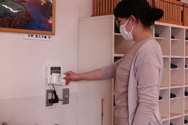 読み取り機にIDカードをかざして出退勤時間を記録。他者が打刻することがないよう、IDカードは必ず持ち帰るという運用ルールも設けた。