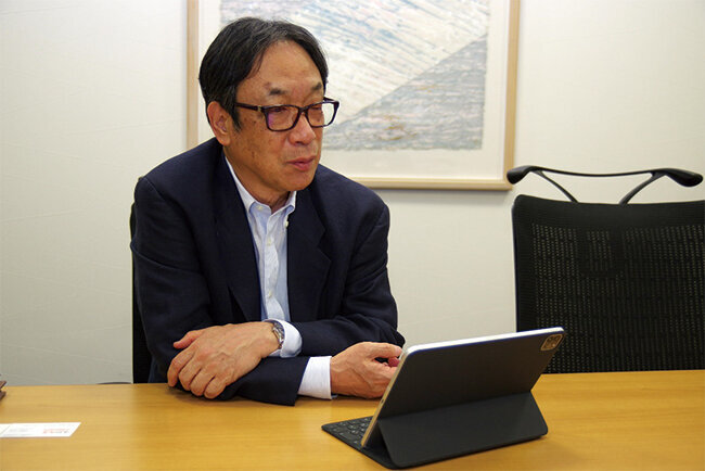 作業現場からの報告を確認している田中晃社長