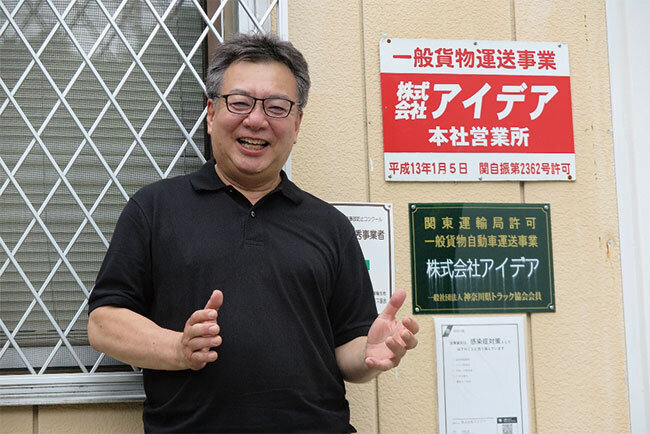 一般貨物自動車運送事業のプレート前で、安田社長