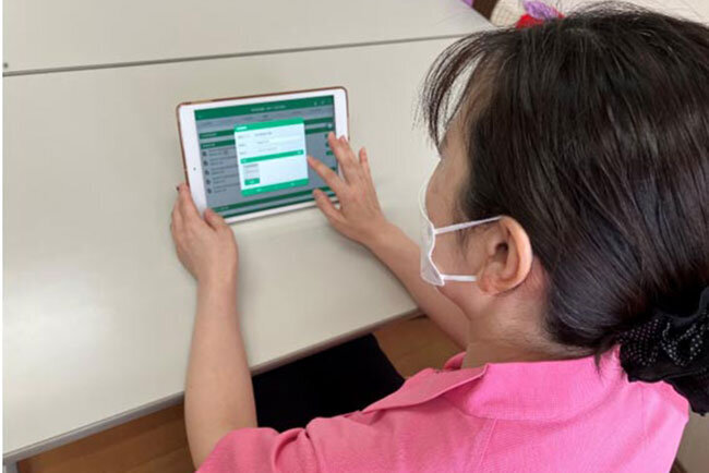 職員の方がタブレットを操作しているところ