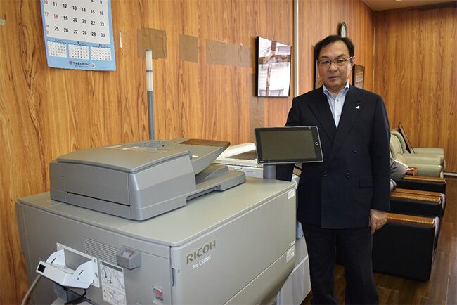 導入したカラー高速デジタル印刷機と皆川社長