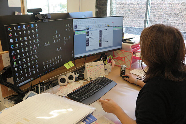 施工管理や原価管理情報が入ったパソコンで作業中の従業員