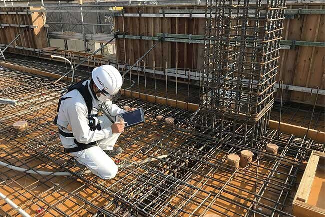 現場でタブレット端末を使って確認する様子
