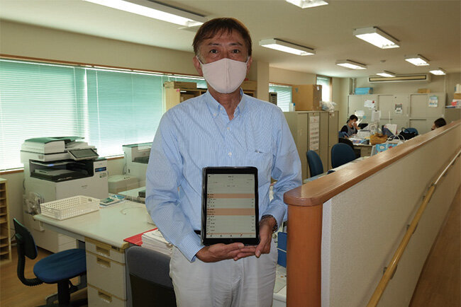 タブレット端末を手にする亀井章夫相談員