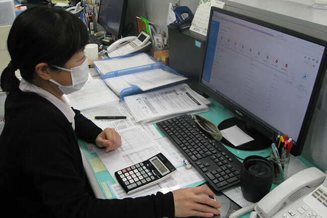 パソコンで進捗状況をチェックするスタッフ