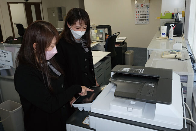 写真・複合機の使い方を共有する石橋奈美さん（左）ら