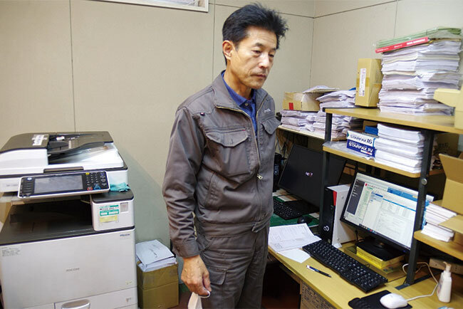 カナックスの事務所でパソコンを見る紺野功代表取締役