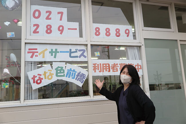 施設入り口前で笑顔の森田社長