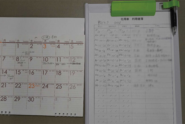 社用車の使用希望者が日時などを記す利用者簿（右）と利用予定を示すカレンダー。近く不要になる見込みだ