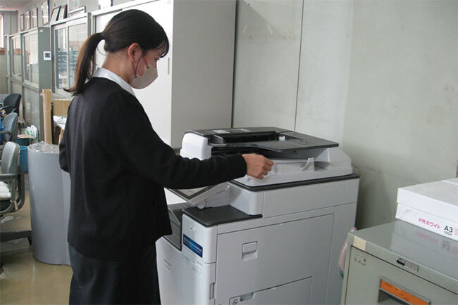 複合機で紙文書をスキャンする様子