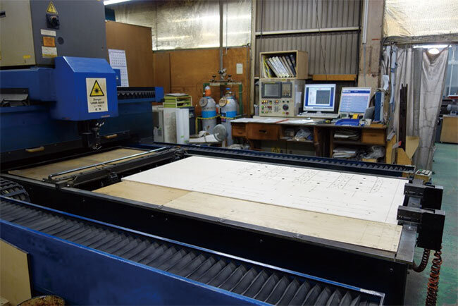 設計図通りにべニヤ板に刃物を入れる溝を描くレーザー加工機