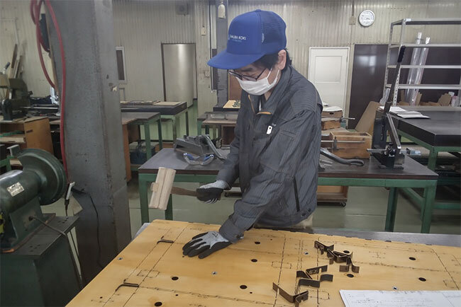 べニヤ板の溝に刃物を入れる作業