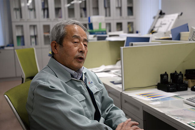 デジタル技術の活用には早期から積極的だったと振り返る猪瀬進保守管理部長。右奥に見えるドラフターは、かつて手描きで図面を作成していた頃のもので、1台だけ残しているという。