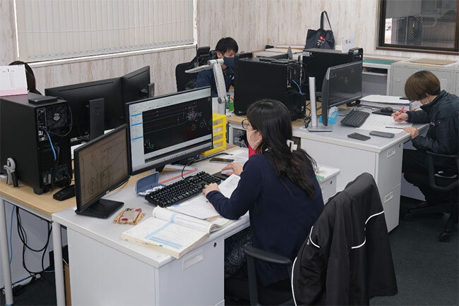 CADを使ってベルトコンベアの設計をする設計部の従業員