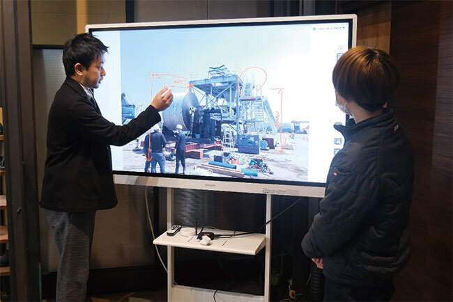 電子黒板を使って現場の状況を示す生藤社長（左）