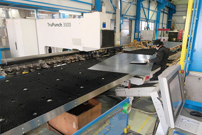 入力データに基づいてカットされた部品を取り出す従業員 