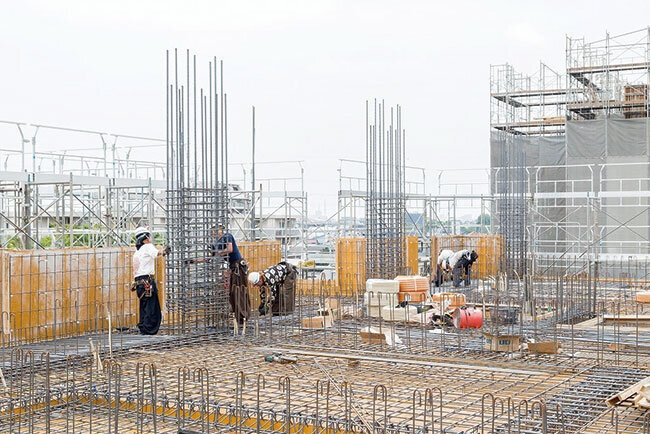 主力はビルの鉄筋工事、壁の鉄筋を組む同社従業員