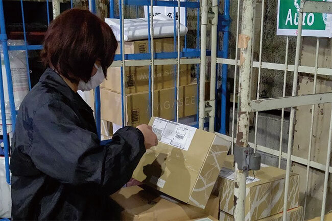 バーコードリーダーで商品を読み取る配達員