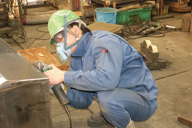 クロムめっきした部品を研磨する従業員