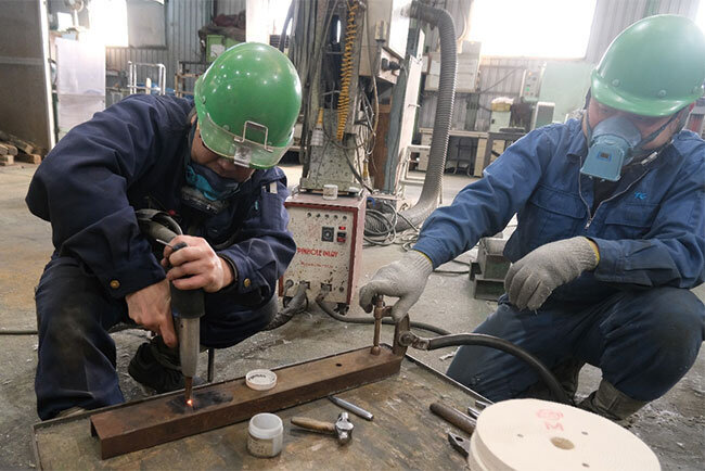 小さな傷を金属熔融充填機で埋める従業員。研磨すると表面はつるつるで傷がわからなくなる