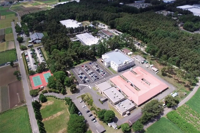 伊那谷の田園地帯の一角に松林に囲まれてある「KOAパインパーク」。本社をはじめ研究開発部門、生産棟、社員用レストランなどで構成している＝KOAチャンネルの動画より
