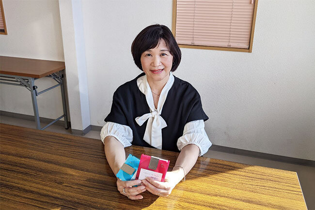 かつて使っていたMOディスクを手にする嶋田真子取締役