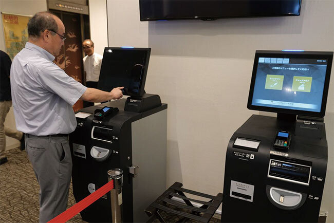 自動精算機を使って見せる絹川正人支配人
