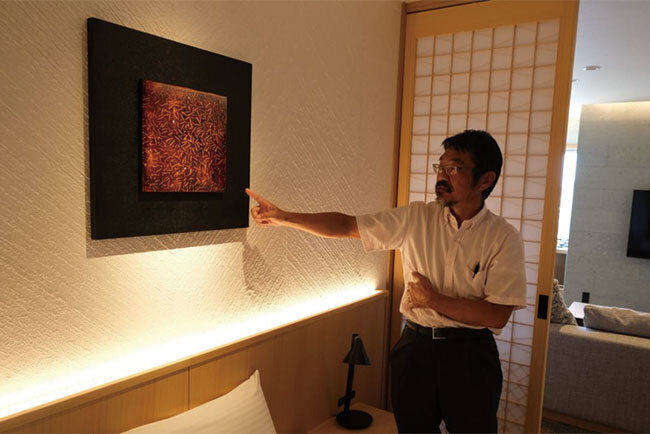 ロイヤルスイートの寝室に掲げられた若狭塗と越前漆器の美術品を説明する尹泰充社長