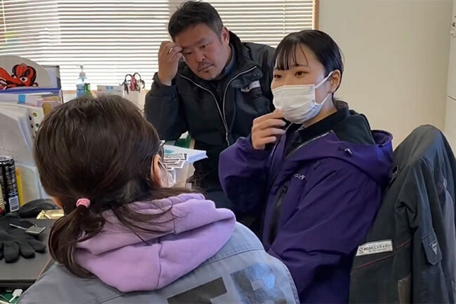 バックオフィスの女子社員と現場の男子社員とのやり取りの風景