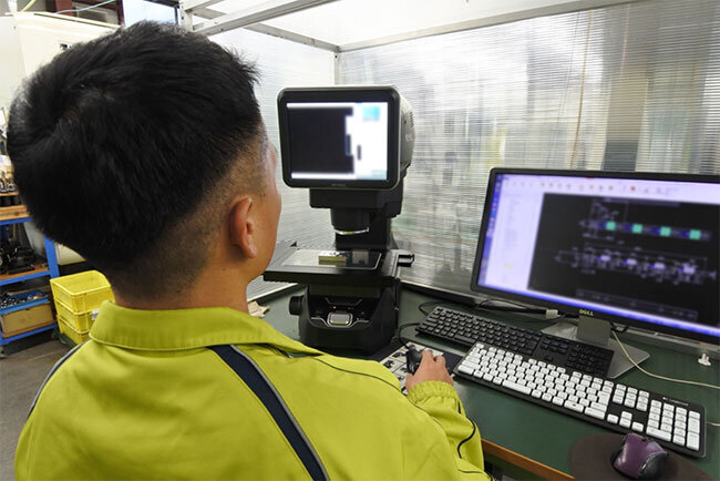 工場内に置かれたCAD・CAM（コンピューターによる設計・製造）（右）と製品の寸法を測定する装置