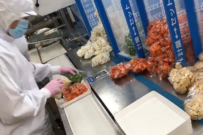 工場でカット野菜を加工し、キットにする様子