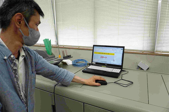 印刷機のモニターを通じて印刷を開始する様子