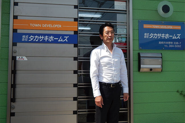 社屋の前に立つ竹内社長