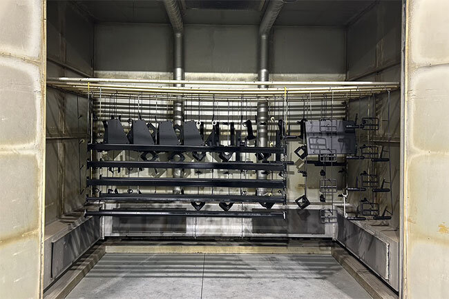 塗料を吹き付けられた後、乾燥炉で焼き付けられた金属部品。ウイルビックの第1工場