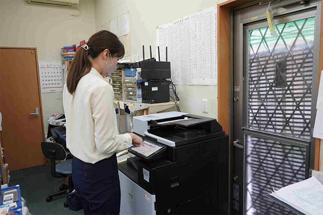 複合機で紙資料をスキャンしてデジタル化する様子